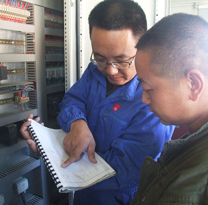 服务工程师陈青松与沥青拌合站操作手进行细致交流